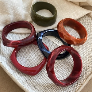 Set of six chunky faceted resin bangles in deep green, marble blue and warm autumn tones