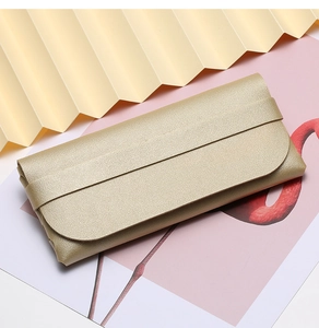 Detail of golden pebble grain leather glasses pouch with elegant envelope flap design