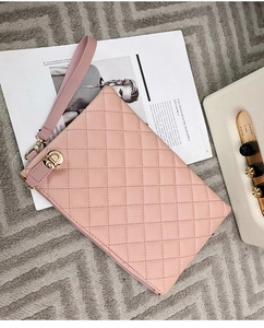 Détail de la pochette matelassée rose avec zip doré et dragonne amovible