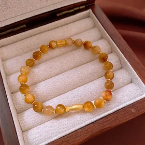 Bracelet vintage en perles d'oeil de tigre avec breloque poisson doré dans son écrin en bois