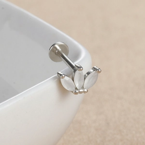 Détail du piercing labret en opale avec pierres en éventail sur bord en céramique
