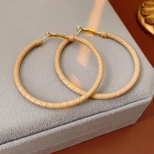 Minimalist geometric circle earrings with khaki leather wrap on golden metal rings