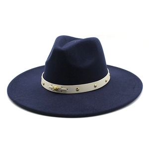 Detail of navy blue wool fedora hat featuring a white leather band with gold rivets