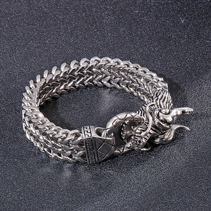 Macro detail of silver dragon head clasp and intricate double-woven chain bracelet