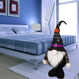 Halloween gnome plush with Happy Halloween hat standing on a striped bedroom floor