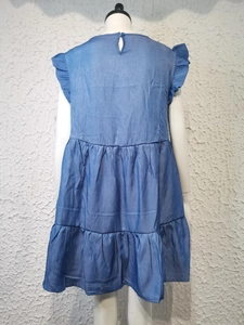 Detail of blue denim style sleeveless dress with ruffle hem and back button closure