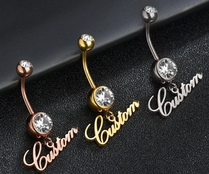 Detailed view of navel rings in gold, rose gold, and silver with custom letter pendants