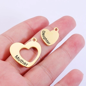 Detailed view of gold heart pendants engraved with Mother and Daughter on palm