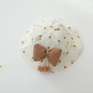 Close-up of baby sun hat with fruit print, large brown bow, and soft tassel drawstring
