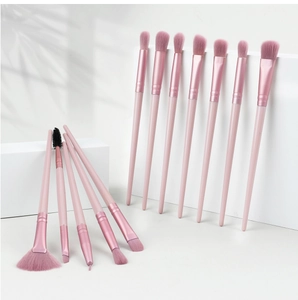 Detail view of 13-piece pink makeup brush set on geometric stands with soft shadows