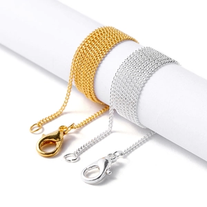 Detail of gold and silver DIY jewelry chains with lobster clasps on white display