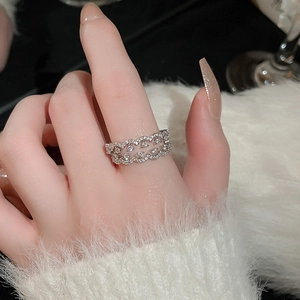 Detail of silver crossover ring with pavé-set zircons on soft faux fur background