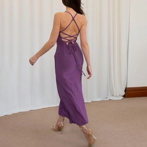 Detail view of the deep purple backless dress with elegant cross straps and a flowing hemline