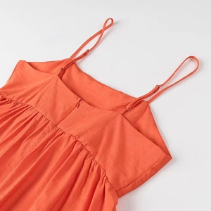 Détail du haut orange avec bretelles réglables et fermeture éclair invisible au dos