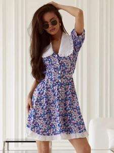 Detail of white ruffled collar and button-down front on purple floral mini dress