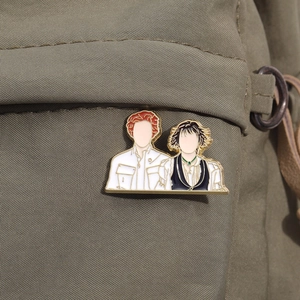 Detailed view of the enamel pins attached to a green canvas backpack for decoration