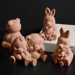 Set di quattro figurine di animali in argilla con conigli e orsi su sfondo nero