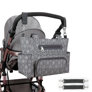 Detail of grey diaper bag with white arrow pattern attached to stroller handles