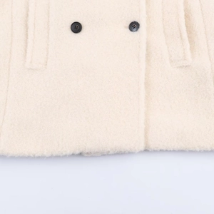 Creamy white double-breasted boucle wool coat with textured fabric and black buttons