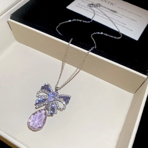 Detail of silver butterfly pendant with pink teardrop crystal on black velvet display
