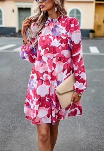 Détail de la robe en mousseline fleurie rose avec jupe à volants et col montant élégant