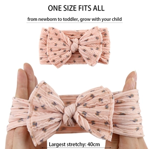 Detail of pink baby headband showing 40cm maximum stretch with soft knotted bow