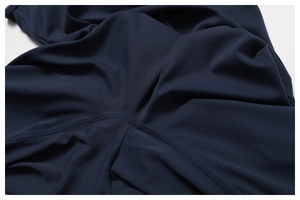 Close-up of navy yoga wear showing reinforced flatlock seams and textured athletic fabric