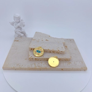 Retro gold-plated round evil eye pendant on a stone base with vintage angel statue