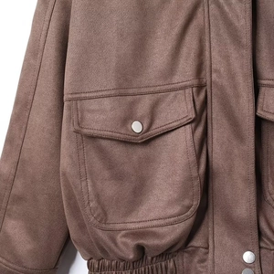 Detailed macro of brown suede jacket showing cargo pockets and metallic buttons