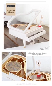 Close-up of white piano music box featuring a rotating ballerina and visible inner gear