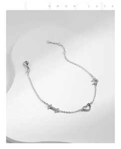 Detail of silver S925 heart bracelet with I and U letter pendants and zircon stones