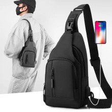 Détail du sac bandoulière noir avec port de charge USB et poche avant verticale