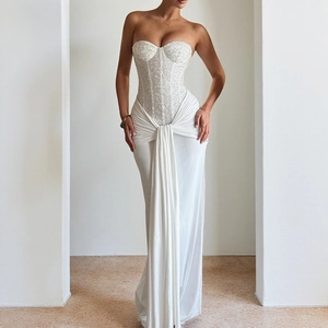 Detailed close-up of a white strapless evening gown with sequined bodice and flowing floor-length hem