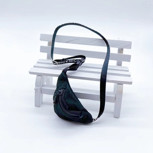 Mini checkered backpack keychain featuring black NICENICE straps on a miniature park bench