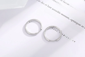 Polished stainless steel hoop earrings featuring a flexible hinged closure mechanism