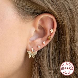 Golden 925 silver earring set featuring butterfly and marquise zircon studs on ear