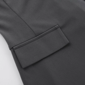 Détail du rabat de poche latérale d'une robe grise ajustée avec texture sergée fine