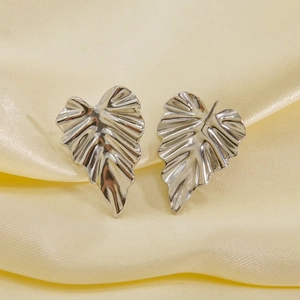Silver leaf shaped titanium steel stud earrings with textured veins on satin fabric