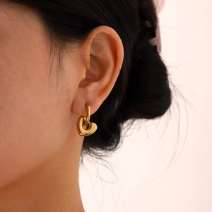 Elegant 18K gold plated heart drop earrings on model showcasing minimalist jewelry design