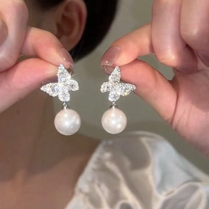 Elegant butterfly stud earrings with sparkling diamonds and round white pearl drop