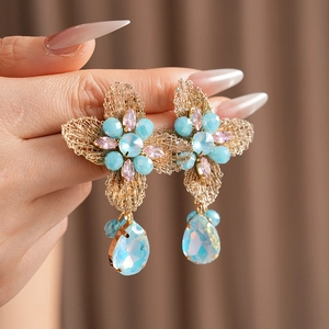 Detail of vintage flower earrings featuring blue and pink crystals with teardrop pendants
