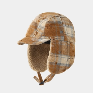 Close-up of vintage distressed plaid trapper hat with warm thick sherpa lining and earflaps