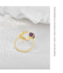 Detail of moon-shaped gold plated ring featuring a raw purple amethyst stone