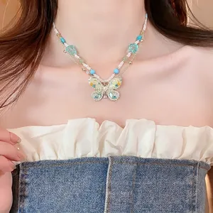 Close-up of a double-layered beaded necklace with a detailed rhinestone butterfly pendant