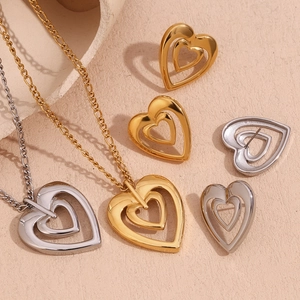 Detailed macro shot of double-layered hollow heart necklace and earring sets in gold and silver
