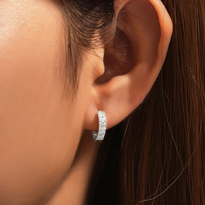 Close-up showing the fit of a silver square hoop earring with micro-pave diamond setting