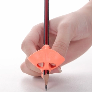 Close-up of orange silicone handwriting aid tool for pencil grip posture correction