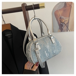 Detail of silver denim handbag with vertical sequins and cylindrical metal handle