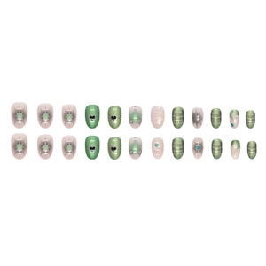Y2K style sage green and pink press-on nails with starburst patterns and 3D black hearts
