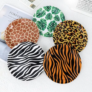 Dettaglio di piatti di carta da 7 pollici con stampe animalier e foglie tropicali